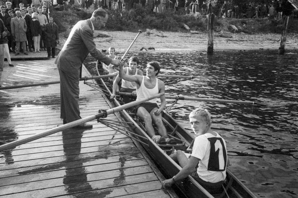 Historisches Bild vom Stadtarchiv Kiel: ein älterer Herr ehrt auf einem Bootssteg einen siegreichen Vierer mit Schülern